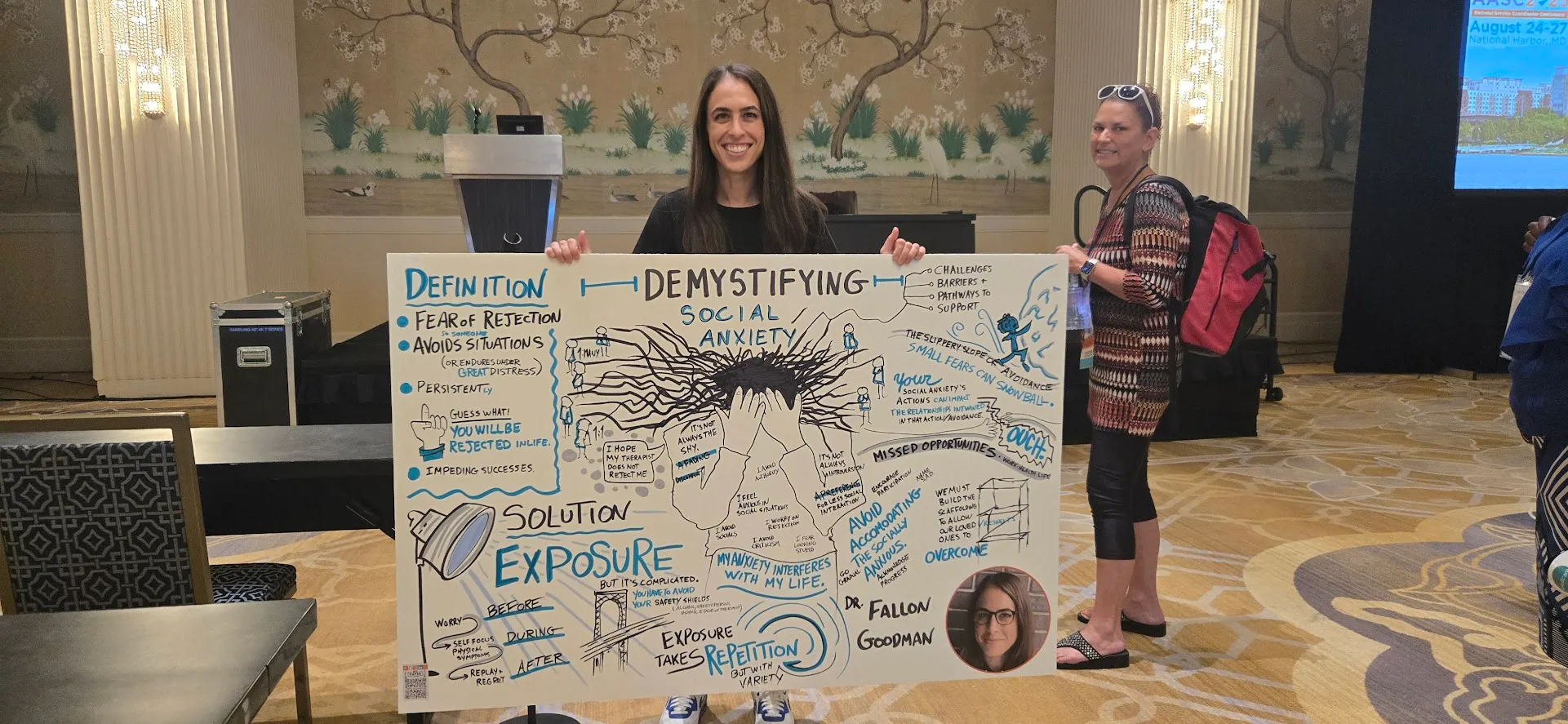 Event speaker holding a panel created by graphic recorder Matt Orley during her session at a DC area conference.