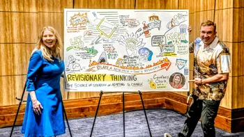 Matt Standing next to a graphic recording on easels with keynote speaker.