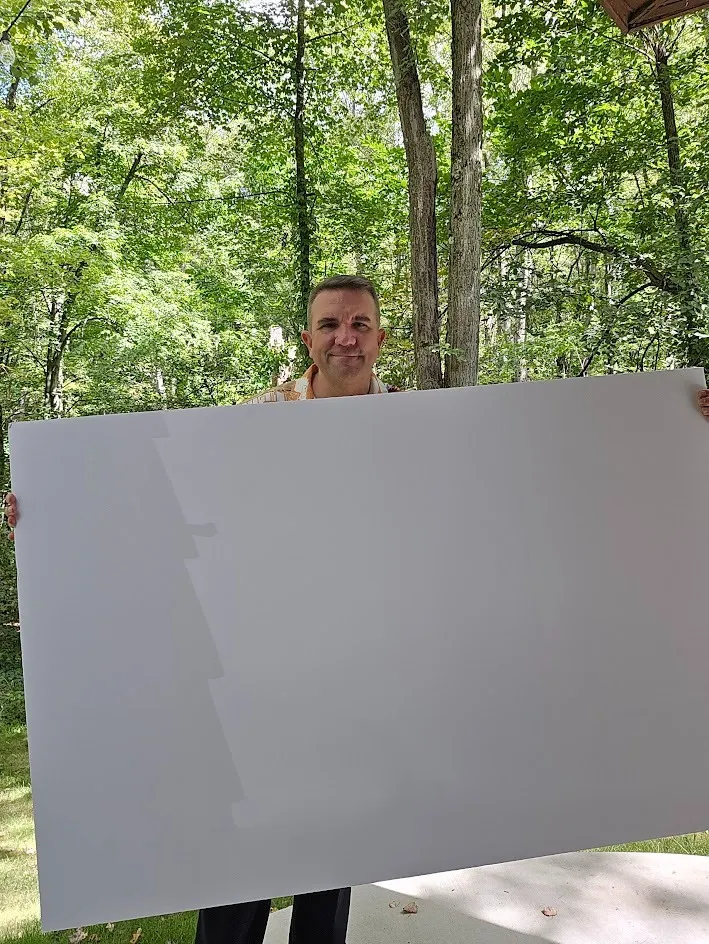 Matt Orley with a blank panel standing in his backyard.