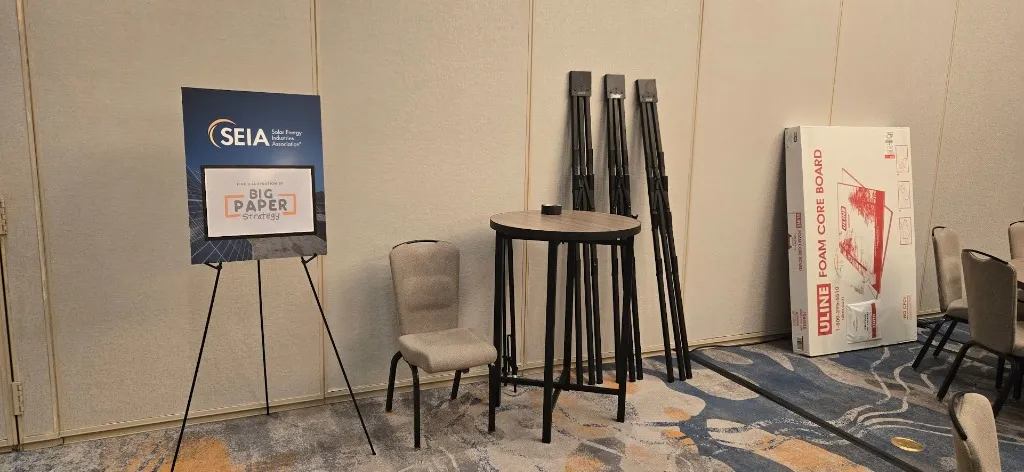 Image of typical large items used during a graphic recording engagement at a conference - high boy table, easels, a box of foam core panels.