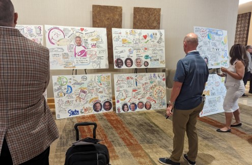 Event Attendees reviewing graphic recordings at a conference